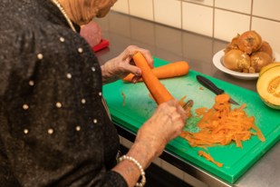Borger hjælper med at skrælle gulerødder