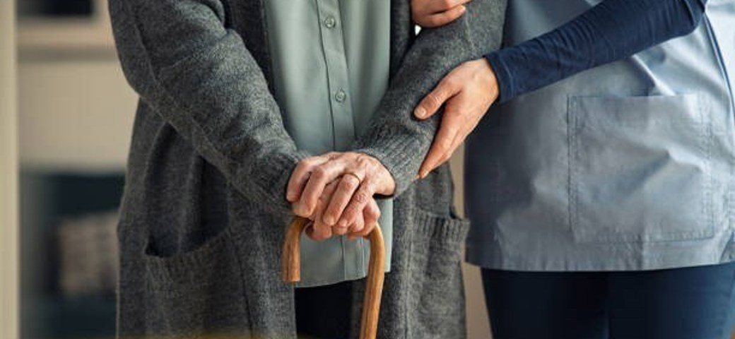 En plejer følger en ældre person med